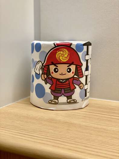 Toilet roll with a wrapper featuring a cartoon samurai
