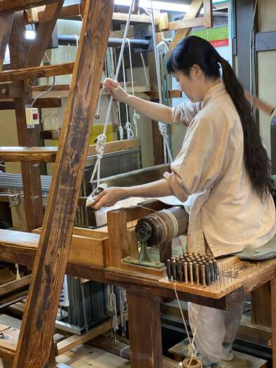 Lady using the Jacquard loom at the merchant’s house