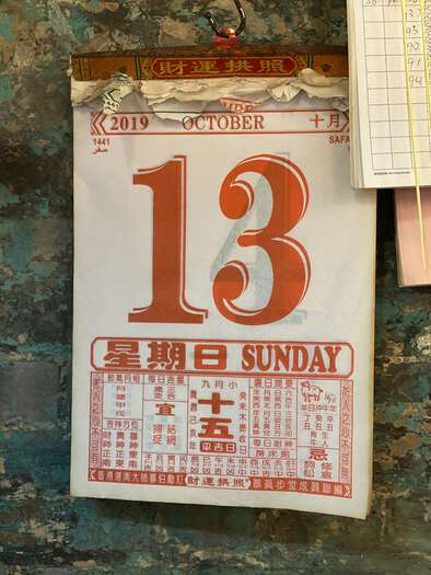 A calendar at Man Mo Temple showing Sunday 13th