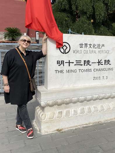 Julijana leaning on a marble Chang Ling entrance sign