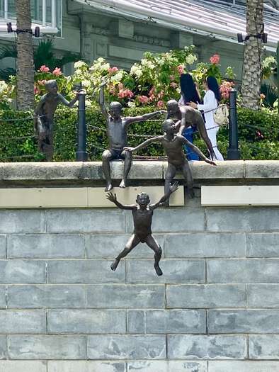 Sculpture of four kids jumping into the river
